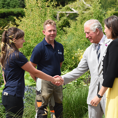 The Prince of Wales meets gardener Emma Bouchard with gardener Paul Eaton and garden designer Marie-Louise Agius right in the Centenary Garden SML squ